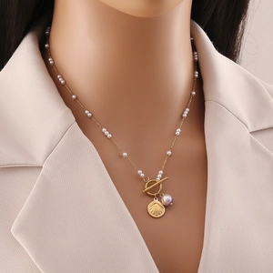 Gold stainless steel ocean necklace with baroque pearl and shell pendant on a model