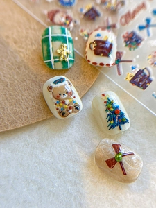 Macro shot of 3D Christmas bear and tree nail art stickers with glitter textures