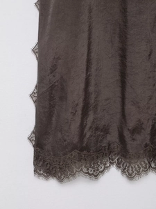 Close-up detail of dark brown satin fabric with delicate lace trim on the hemline