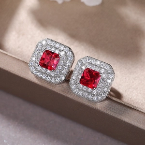 Macro detail of square red zircon earrings with double halo diamond pave setting