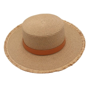Detail of flat top straw hat with brown leather band and frayed fringe brim edge