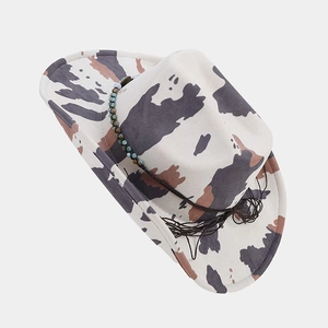 Close-up of cowboy hat crown with blue beads and cow print felt texture details