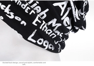 Detail of black slouchy beanie featuring white graffiti letter prints and stacked design