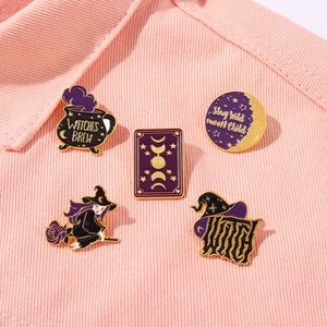 Detail of vintage witch enamel pins set on pink denim jacket featuring magic brew potion