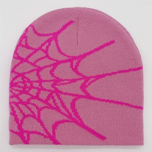Close-up of pink knit beanie showing detailed magenta spider web jacquard pattern
