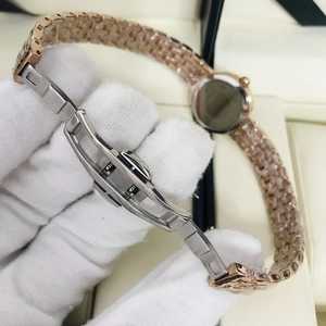 Close-up of rose gold mesh watch strap with butterfly deployment clasp and protective film
