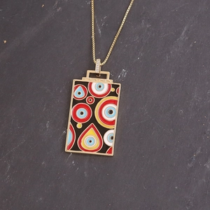 Gold square evil eye pendant necklace with colorful enamel detailing on grey stone
