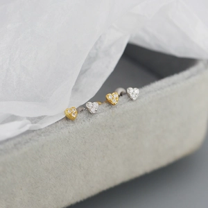 Detailed close-up of tiny heart-shaped s925 silver stud earrings with sparkling diamonds