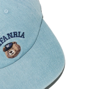 Dettaglio del ricamo dell'orso e della scritta FANRIA sul cappellino in denim azzurro