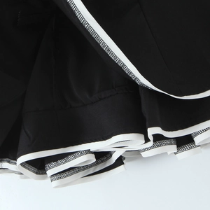 Retro black and white tube dress with sweet bow accents and layered ruffle hemline