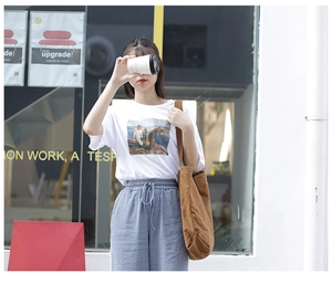 Outdoor street style shot of the large brown canvas tote bag paired with casual outfit