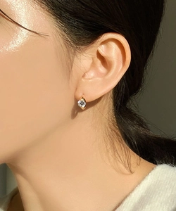 Close-up of elegant gold cubic zirconia stud earring worn for a minimalist aesthetic