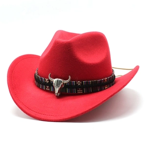 Détail du chapeau de cowboy rouge avec bande ethnique et ornement de crâne de taureau