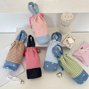 Detail of colorful checkered drawstring bottle bags with denim star pattern bases