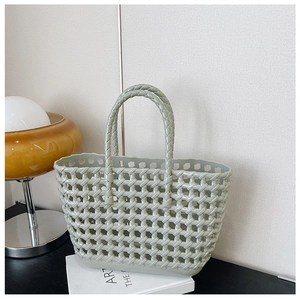 Macro shot of a light grey-green woven jelly bag placed on a book near an amber lamp