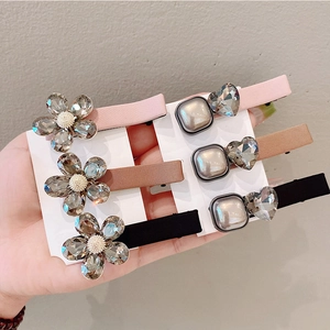 Detail of lace hair clips featuring crystal flowers and pearls on display cards