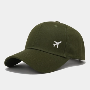 Gros plan de la broderie avion sur casquette de baseball en coton vert avec coutures