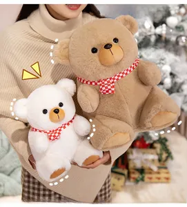 Detail of plush teddy bears with red checkered scarves in a cozy Christmas setting
