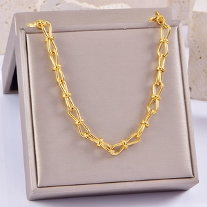 Macro detail of gold knot links on a thick hip-hop chain over a grey velvet box