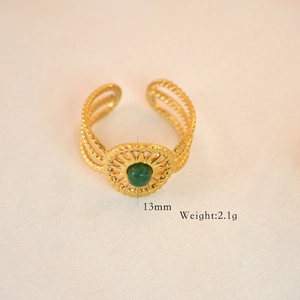 Detail view of gold ring with green stone, multi-layer hollow texture, 13mm width