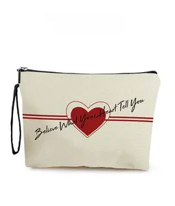 Dettaglio borsa in tela con motivo a cuore e scritta 'Believe Your Heart' nera