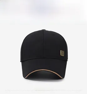 Detail of black baseball cap featuring khaki brim edge and vintage bronze metal badge