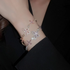 Close-up of elegant butterfly bracelets with pink zircons and rose gold finishes