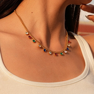 Detail of a gold plated stainless steel necklace with multi-colored gemstone pendants