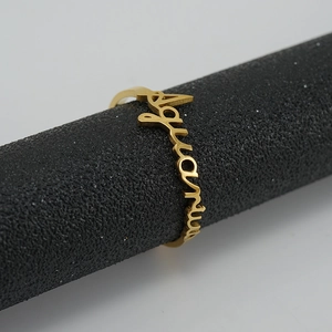 Macro side view of an 18K gold-plated Aquarius zodiac ring on a jewelry display stand