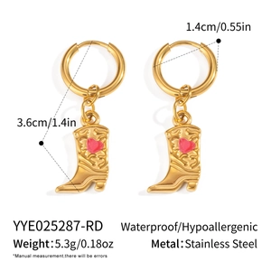 Détail de boucles d'oreilles bottes de cow-boy en acier doré 18K avec cœur rose