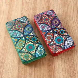Ethnic mandala print long wallets with gold zippers on a rustic wooden background
