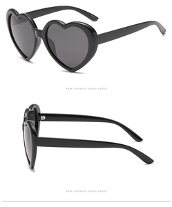 Detail view of heart-shaped polarized sunglasses with a thick black frame from multiple angles