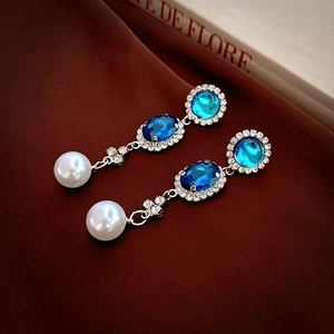 Vintage style drop earrings with blue gemstones, white pearls, and sparkling rhinestones