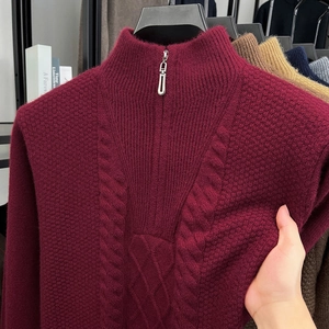Detail eines weinroten Strickpullovers mit halbem Reißverschluss und Zopfmuster