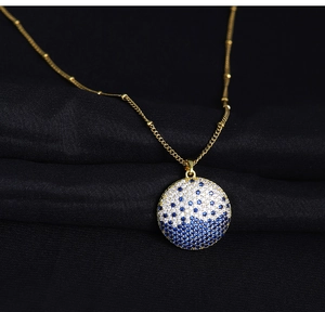 Macro shot of elegant planet pendant with blue and white crystals on black silk