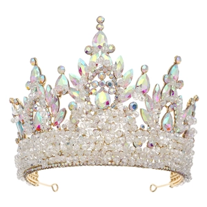 Detailed close-up of golden crown with pink AB crystals and intricate beadwork on white background