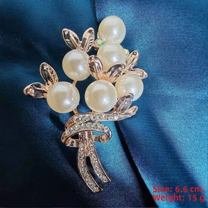 Close-up of rose gold floral brooch with pearls and rhinestones on blue silk, 6.6 cm