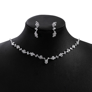 Sparkling zircon flower bridal necklace and teardrop earrings set on a black bust display