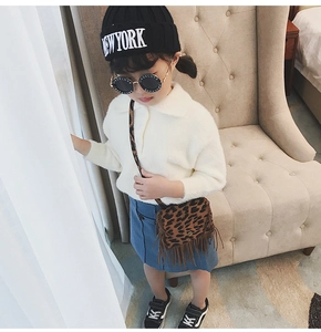 Detail of child wearing a leopard print tassel crossbody bag with white knitwear