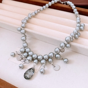 Dettaglio della collana di perle grigie con pendente in cristallo e paillettes metalliche