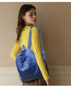 Blue rivet backpack detail showing faux leather texture and gold studs on female model