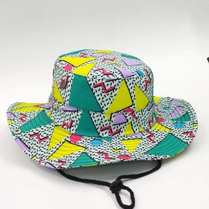 Reversible bucket hat with vibrant Memphis geometric print and adjustable chin strap