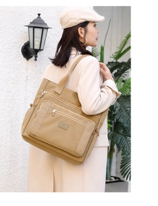 Détail du sac cabas en nylon kaki montrant plusieurs poches zippées et bandoulières