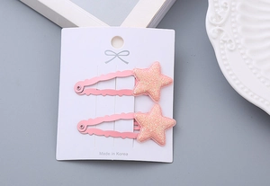 Close-up of two pink glitter star hair clips on a white card for girls' hairstyles