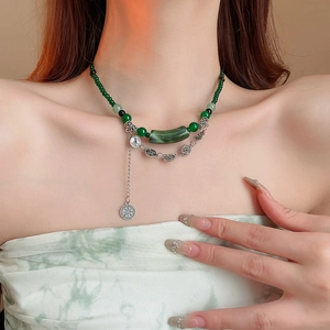 Détail du collier double en perles de bambou vert avec pendentif pièce rétro