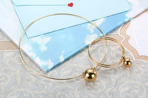 Détail de l'ensemble collier et bracelet dorés avec sphères creuses au fini poli