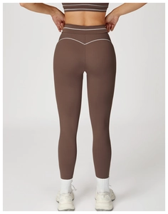 Detail view of high-waisted yoga pants featuring contrast white piping on dark coffee fabric