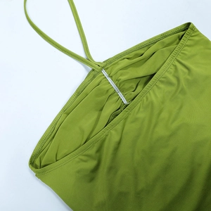 Detailed close-up of green backless dress showing pleated neckline and slim straps