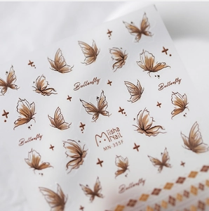 Macro detail of vintage brown butterfly nail art stickers with delicate embossed textures