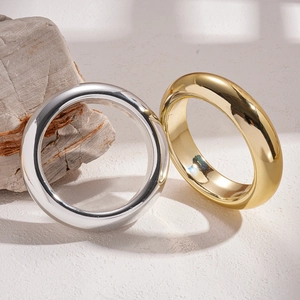 Minimalist geometric round metal bracelets in polished gold and silver on natural stone